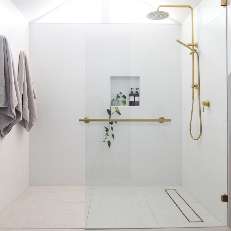 Brushed brass tap mixer on timber vanity with white basin bowl a